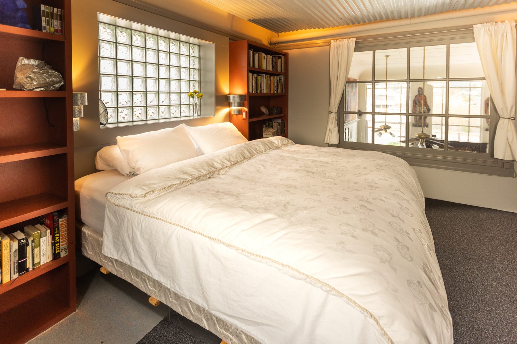 Bedroom at Not A Bank with bookshelves and historic interior windows